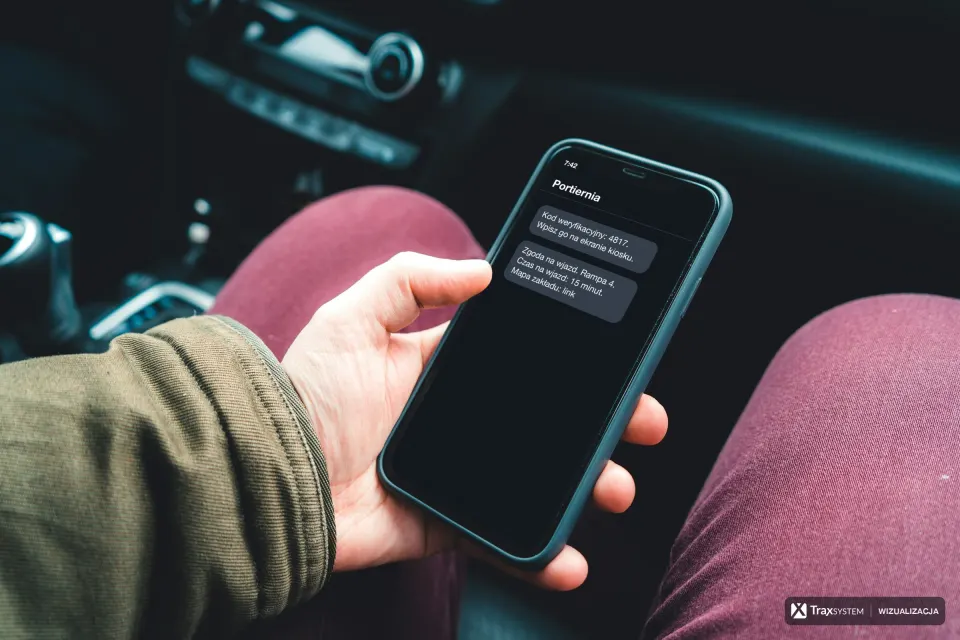 Dłoń trzyma telefon we wnętrzu samochodu. Na ekran naniesiono wizualizację SMS-ów od nadawcy „Portiernia”: kod weryfikacyjny do wpisania na kiosku oraz zgodę na wjazd na rampę 4 z czasem na wjazd i linkiem do mapy zakładu.