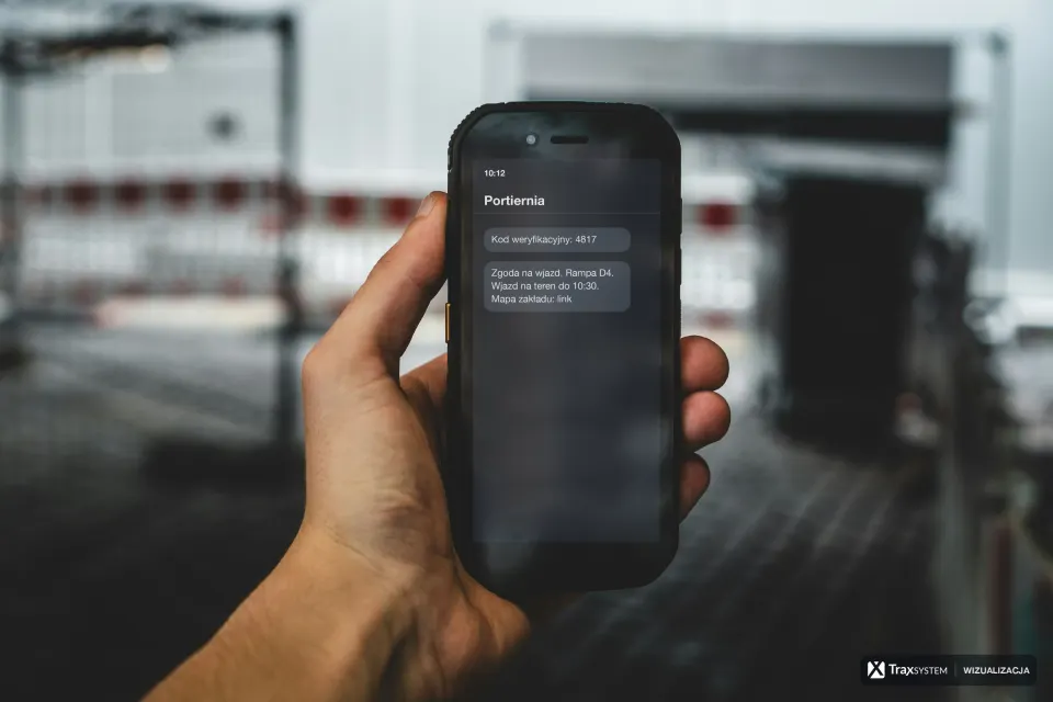 Dłoń trzyma wytrzymały smartfon na tle rozmytej hali z biało-czerwoną barierką. Na ekran naniesiono wizualizację SMS-a od nadawcy Portiernia: kod weryfikacyjny i zgodę na wjazd na rampę D4 do 10:30 z linkiem do mapy zakładu.