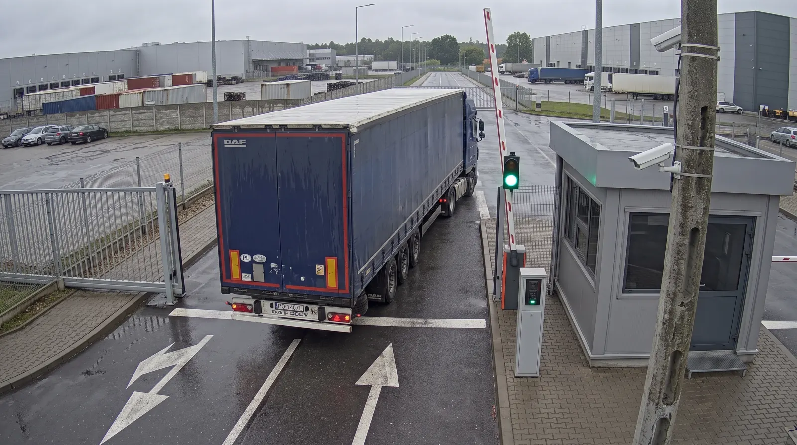 Illustrative camera frame at the exit gate: an articulated lorry drives out under a raised barrier, with a camera on a pole, a traffic light showing green and a security booth. Overlaid are the numbered points, the plate-read frame and a card for the closed visit.